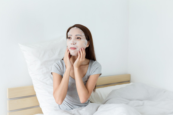 Asian woman using facial mask - Foto, Imagen