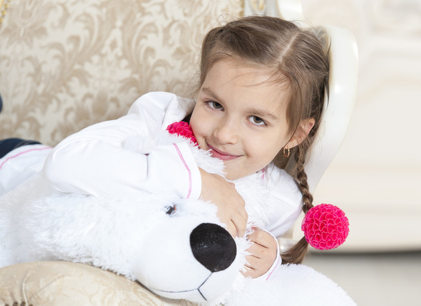 Gelukkig meisje met teddybeer en bloem op leunstoel - Foto, afbeelding