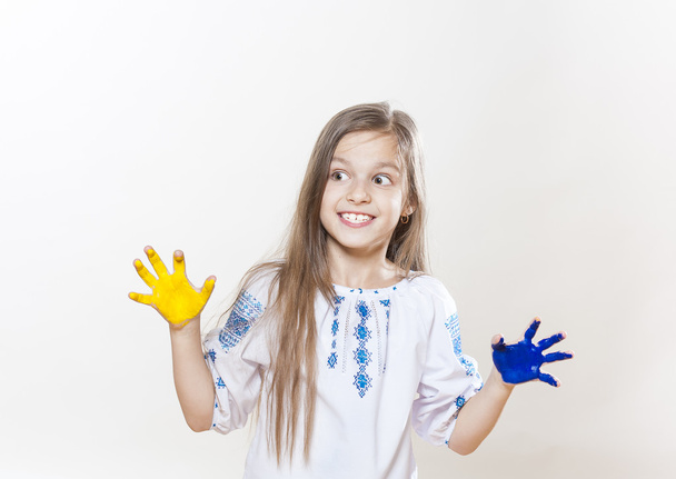 Jong meisje in borduurwerk met gele en blauwe kleuren van de handen - Foto, afbeelding