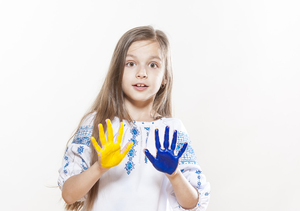 Jong meisje in borduurwerk met gele en blauwe kleuren van de handen - Foto, afbeelding