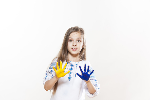 Young girl in embroidery with hands yellow and blue colors - 写真・画像