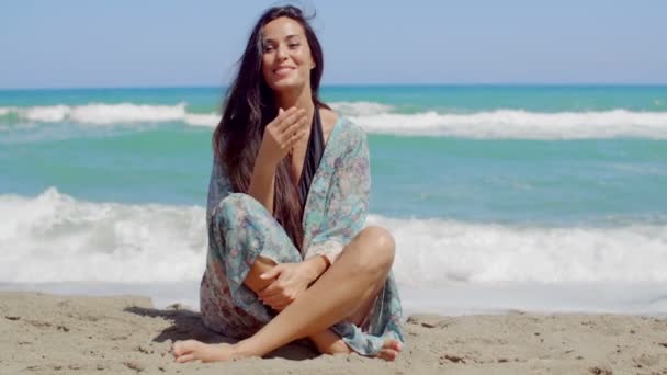 hübsches Mädchen sitzt auf Sand am Strand - Filmmaterial, Video