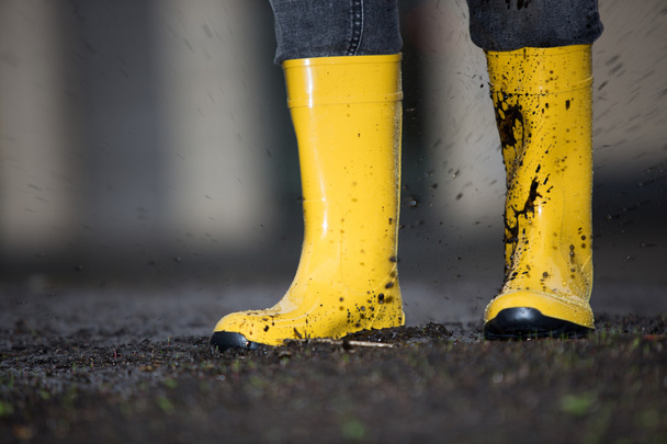 Yellow rubber boots  in a dirty puddle - Foto, imagen