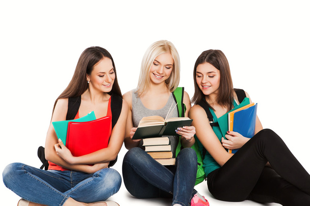 drie studenten met copybooks samen zitten op een witte achtergrond - Foto, afbeelding