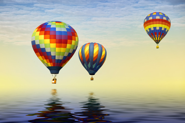 Three hot air balloons over water - 写真・画像