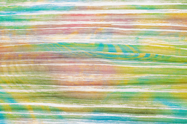Skládaná textilie s barevné abstraktní kresby. Full frame se z plisované látky s ležérní, hippie jako vzor - Fotografie, Obrázek