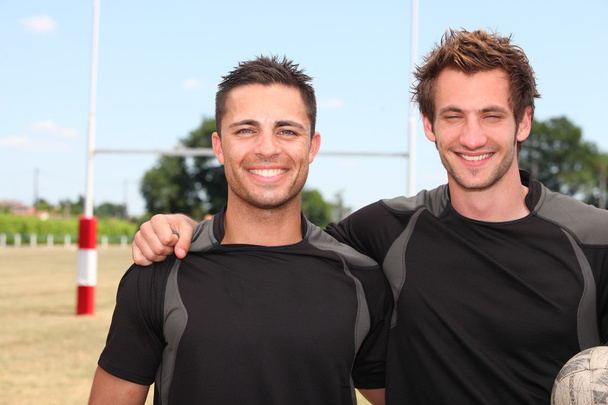 Two rugby players posing with ball in front of goal - Photo, image