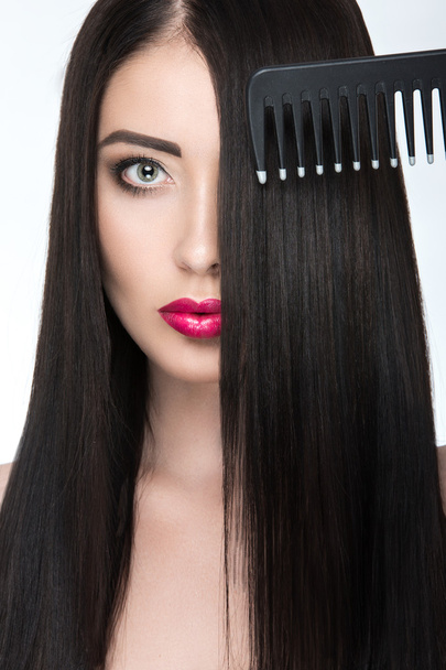 Beautiful brunette girl with a perfectly smooth hair, hairbrush and classic make-up. Beauty face.  - Фото, зображення