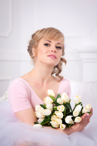 Beautiful blonde woman with a bouquet of tulips - Foto, imagen