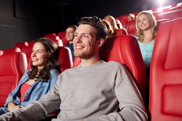 happy friends watching movie in theater - Foto, afbeelding