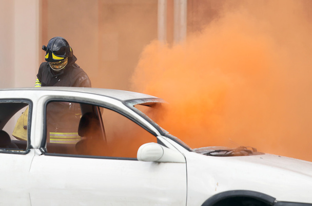 πυροσβέστες κατά τη διάρκεια άσκησης να σβήσουν μια πυρκαγιά σε ένα αυτοκίνητο - Φωτογραφία, εικόνα