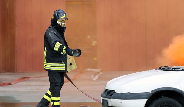 Feuerwehrleute bei Übung, um einen Brand in einem Auto zu löschen - Foto, Bild