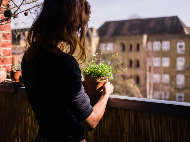 Frau pflegt ihre Pflanzen auf Balkon - Foto, Bild
