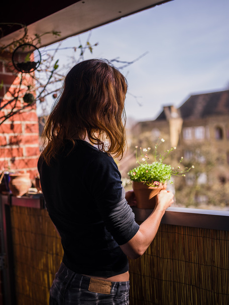 Mulher atendendo suas plantas na varanda
 - Foto, Imagem