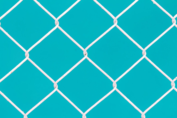 Белый проволочный забор на зеленом фоне
 - Фото, изображение