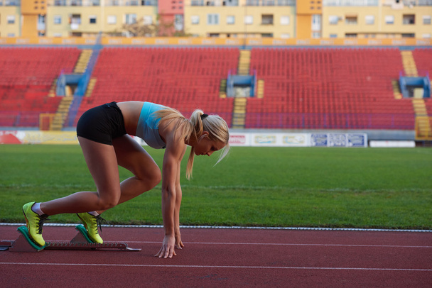 woman  sprinter leaving starting blocks - Foto, Bild