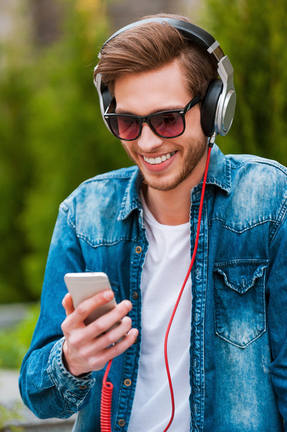 man in headphones holding mobile phone - Photo, image
