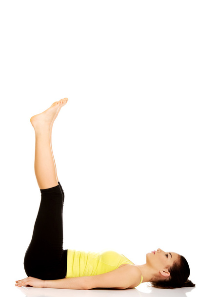 Fitness woman with her legs up. - Zdjęcie, obraz