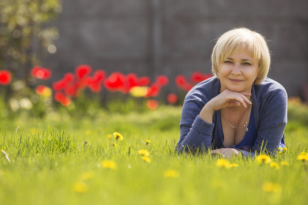 Belle sureau blonde femme âgée se détendre sur une herbe dans le dos
 - Photo, image
