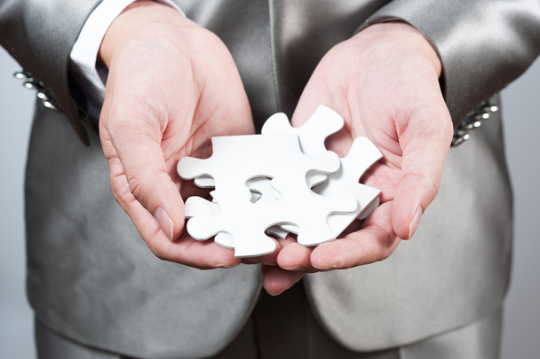 бізнесмен показує білу головоломку в руці, концепція бізнес-стратегії
 - Фото, зображення