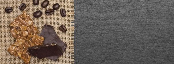 Sweets and coffee beans on anthracite background in header size - Photo, Image