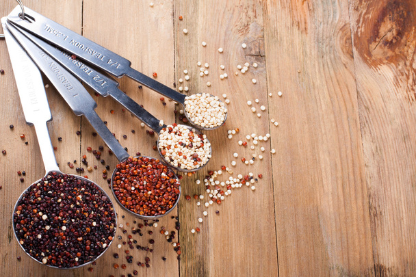 Mix of quinoa grain in metal measuring spoons - Photo, image