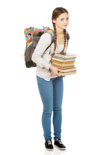 Beautiful teenager with backpack and books. - Фото, изображение