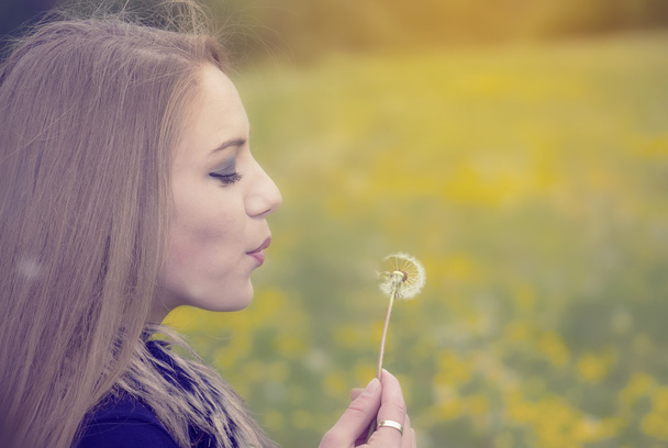 Pretty girl blowing a dandelion - Photo, Image