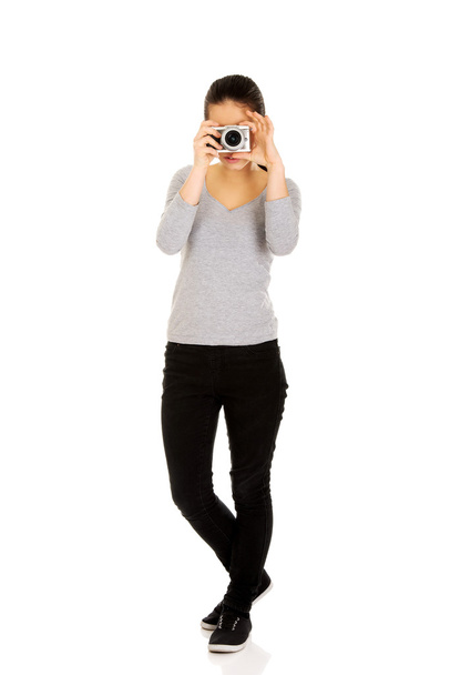 Woman taking a photo with a camera. - Zdjęcie, obraz