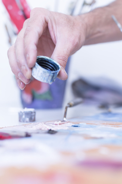 Pintor añadiendo agua a la pintura - sesión de pintura
 - Foto, imagen