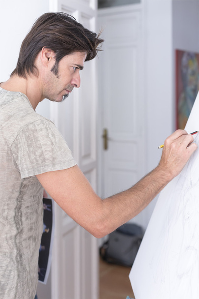 Young man drawing on canvas - painting session - Photo, Image