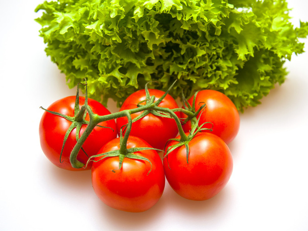 Branch of red ripe tomatoes and bunch of salad - Photo, Image