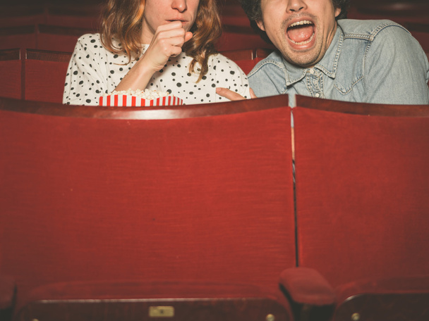 Couple watching a scary film in a movie theater - Фото, изображение