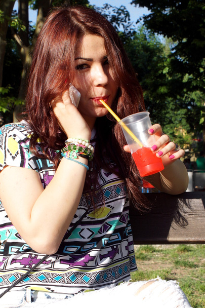 Young lady eating slush in the park - Zdjęcie, obraz