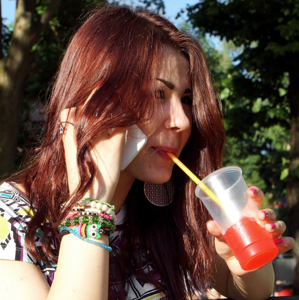 Young lady eating slush in the park - 写真・画像
