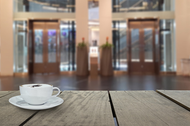 Nieostrości z taras drewno i kawy cappuccino z windy w centrum handlowego na tle użycia - Zdjęcie, obraz
