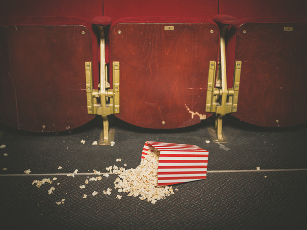 Spilled popcorn on floor in cinema - Фото, изображение
