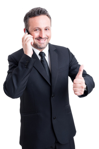 ビジネスの男性が携帯電話で話すし、親指が現れる - 写真・画像