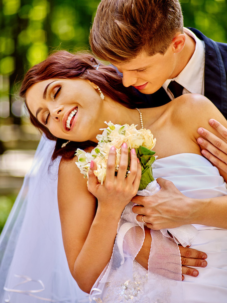 Bride and groom with flowers outdoor. - Foto, afbeelding