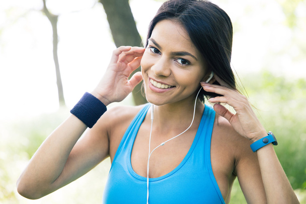 Smiling sporty woman in headphones outdoors - Foto, Bild