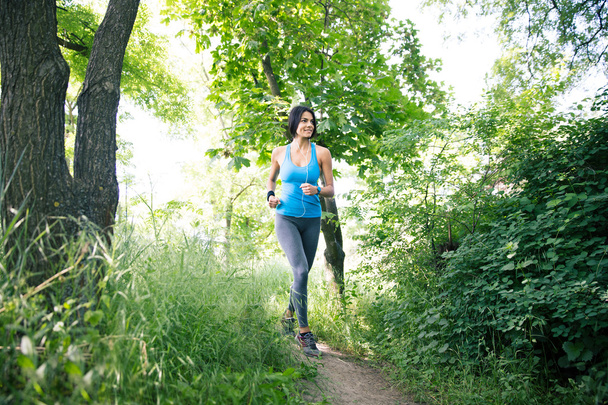 Smiling sporty woman running outdoors  - Fotoğraf, Görsel