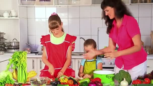 Madre e hijas cocinando comida en la cocina
 - Imágenes, Vídeo