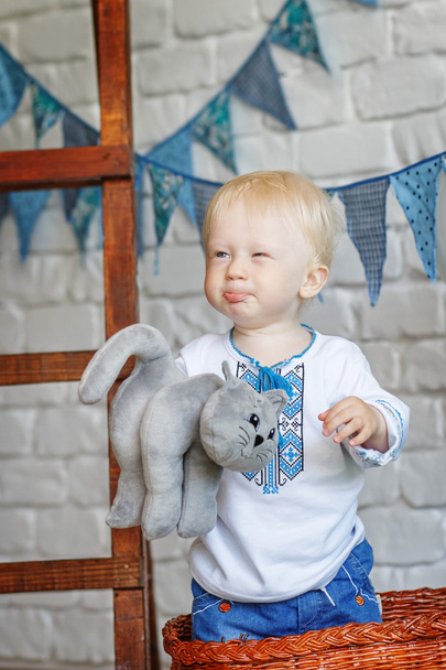 Portrait of a funny little boy with a toy kitten - Фото, изображение