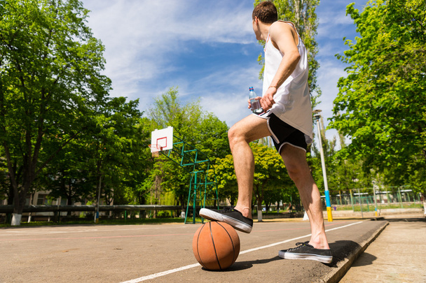 Man with Foot on Basketball Looking Towards Basket - Fotoğraf, Görsel
