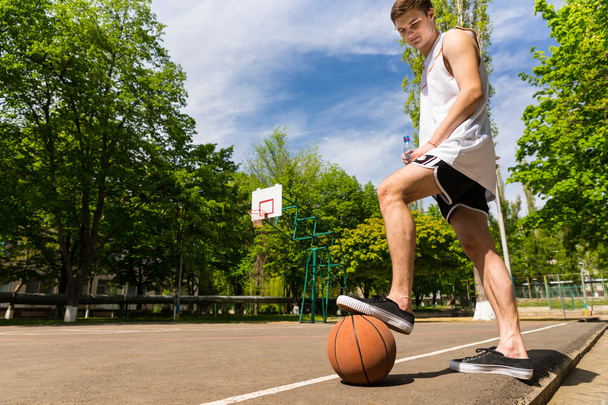 Man Standing with Foot on Basketball on Court - Fotoğraf, Görsel