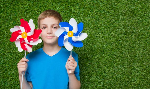 Smiling boy holding pinwheels  - Foto, afbeelding
