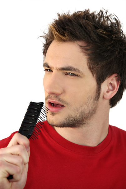 Young man holding hairbrush as makeshift microphone - Φωτογραφία, εικόνα