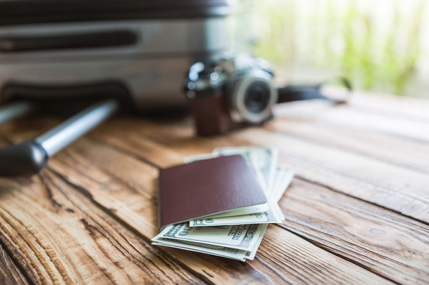 Blank passport and camera with US dollars on wood table - Valokuva, kuva