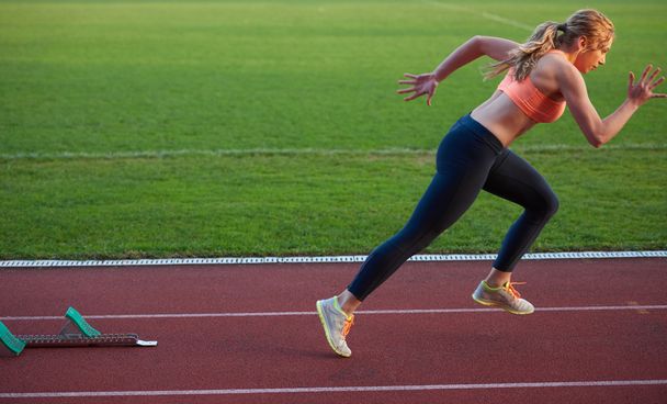 woman  sprinter leaving starting blocks - Fotografie, Obrázek