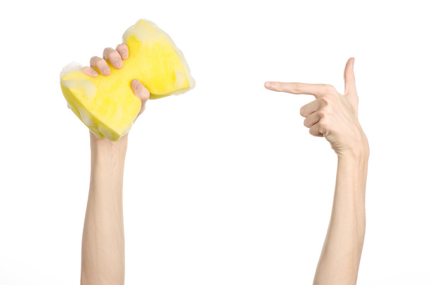 Pulizia della casa e igiene argomento: mano che tiene una spugna gialla bagnata con schiuma isolata su uno sfondo bianco in studio
 - Foto, immagini
